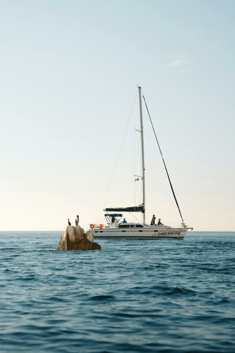 Sailboat near rocks in Baja California Sur with clear blue sky.
